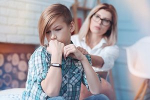 Teen comforted by parent during a teenage process addiction treatment program