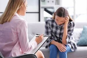 a teen girl talks to a counselor in her vicodin addiction treatment program